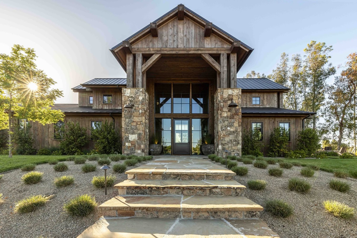 Timber-frame home entry framed by tall Sierra Pacific windows